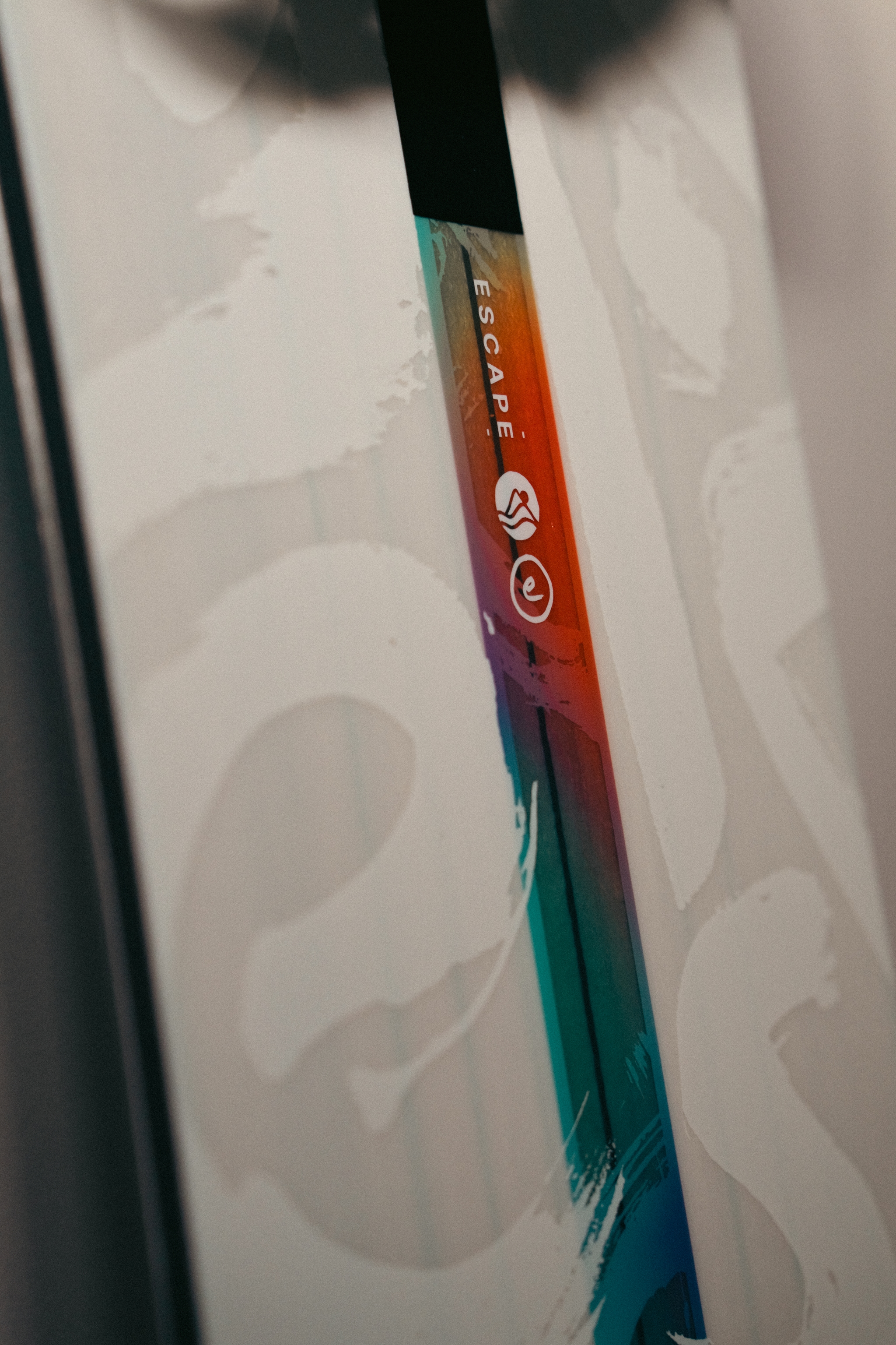 closeup of a vertical multicolored gradient strip set into a pale surface with large abstract lettering