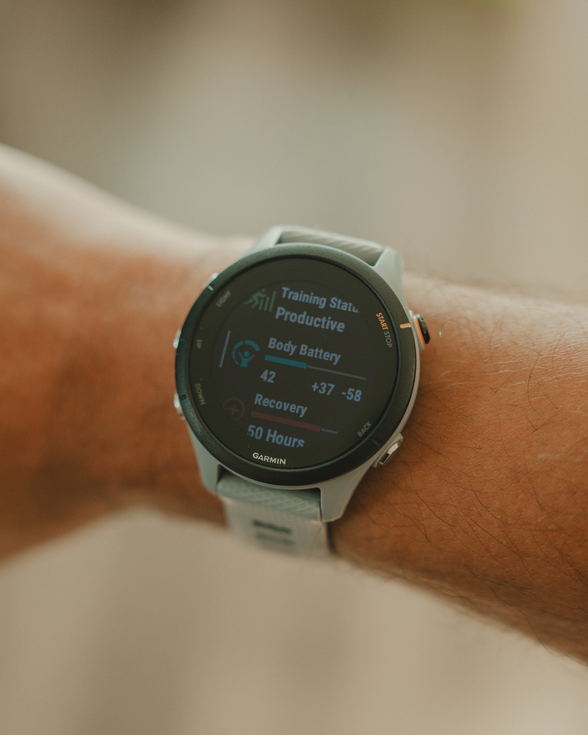 A smartwatch displaying fitness metrics like training status, body battery, and stress level on a person's wrist