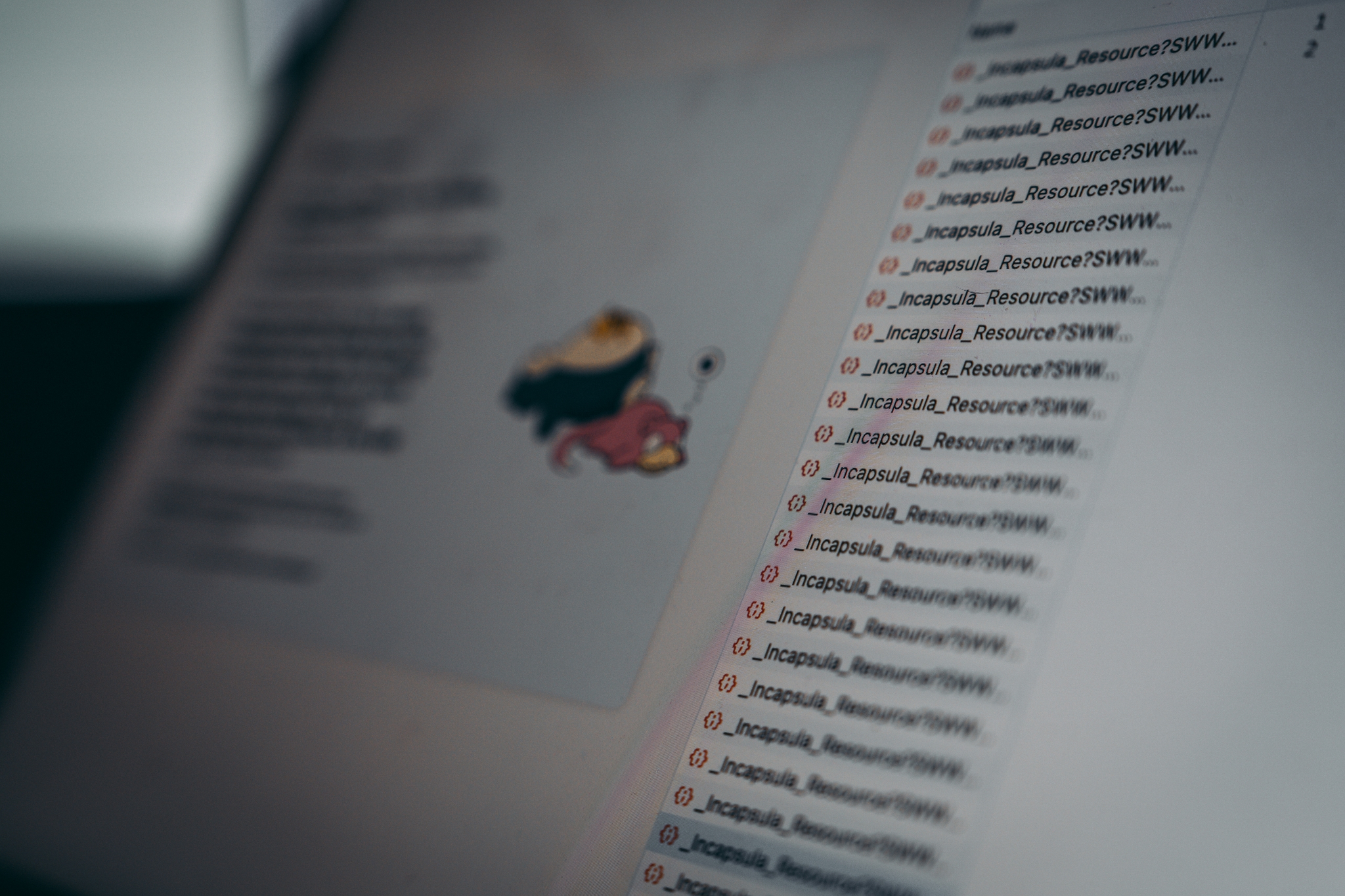 A blurred computer screen displaying a list of image files titled Screenshotxxxx on the right side, with a partially visible cartoon or graphic on the left