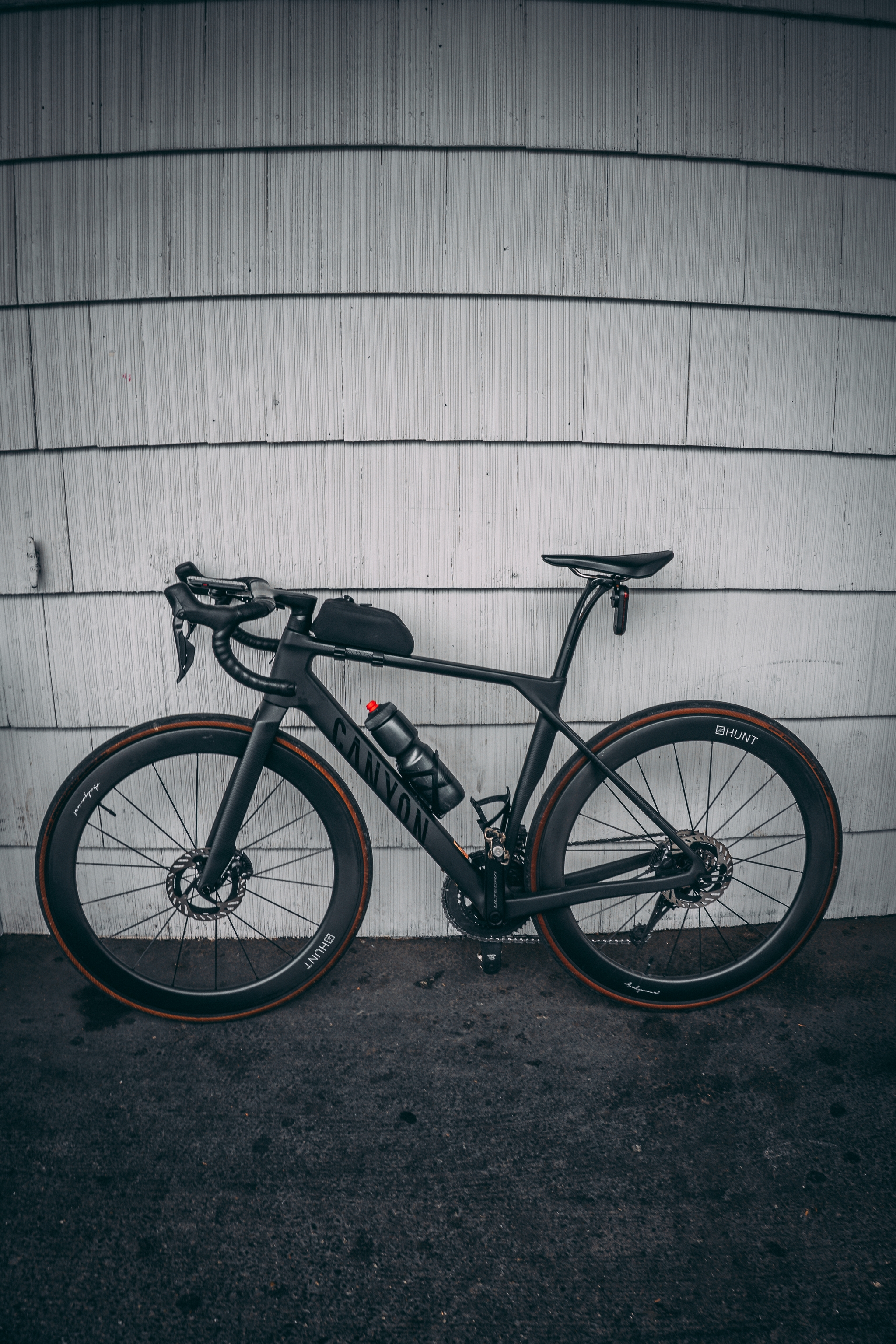 A black bike leaned against a wall