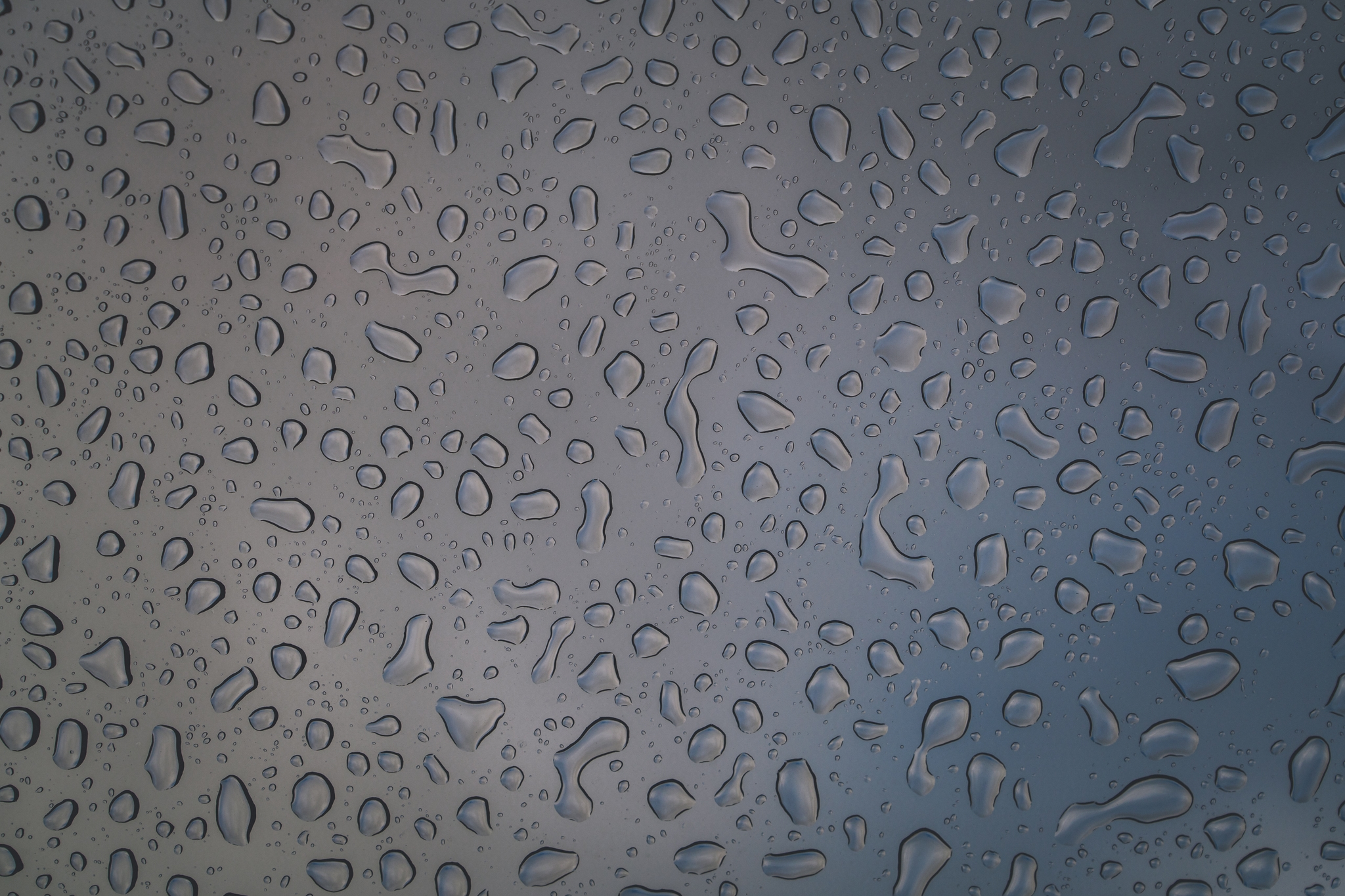 Water droplets on a glass surface with a blurred background