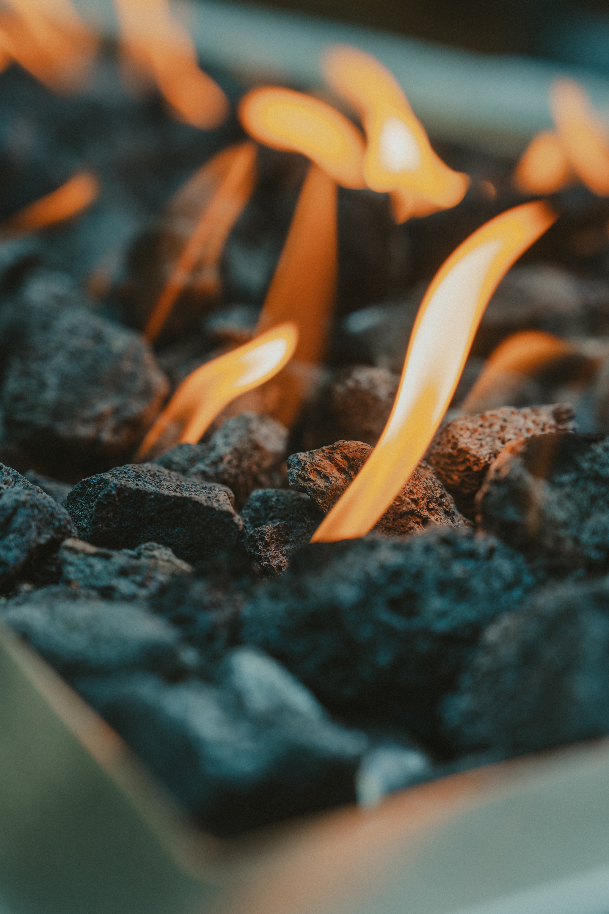 Flames rising from a bed of dark, textured rocks