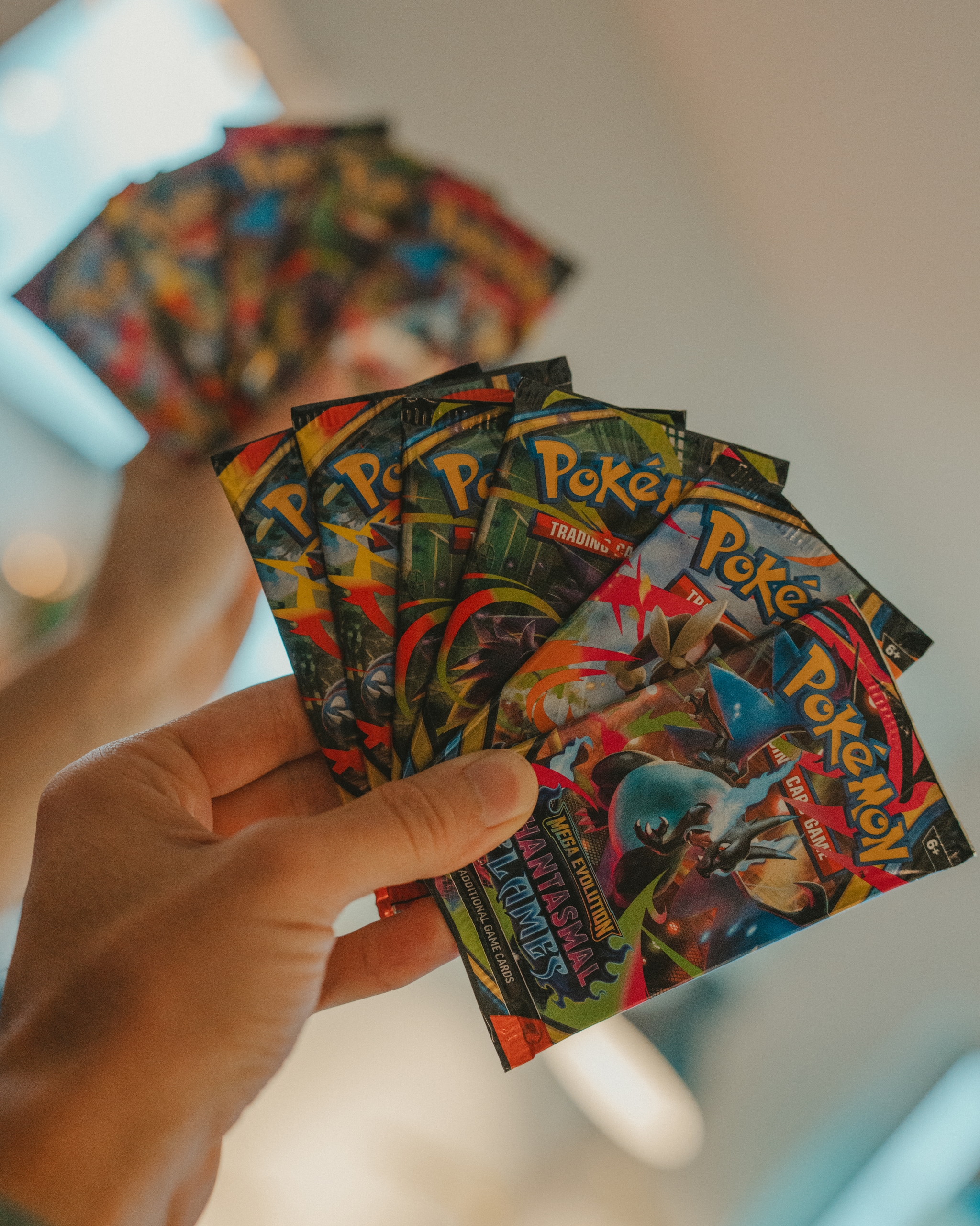 Hands holding colorful Pokémon trading cards