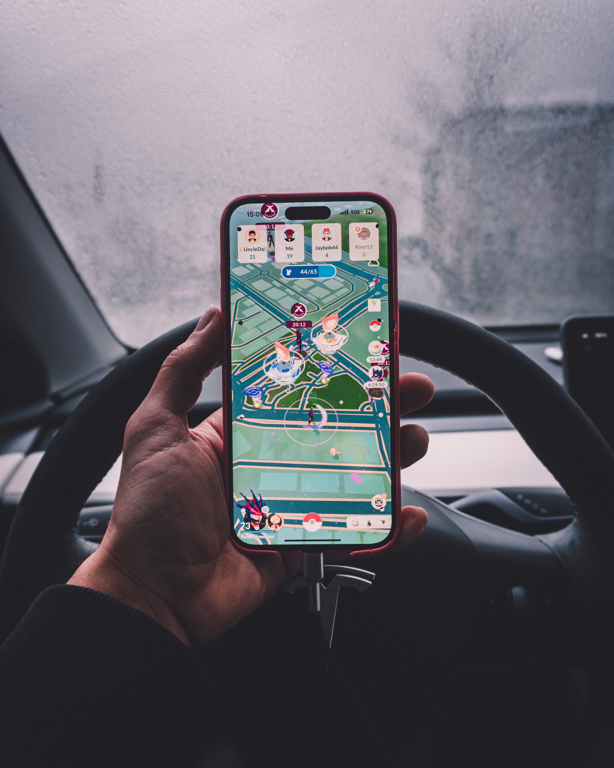 A mobile game displayed on a smartphone held by a person inside a car