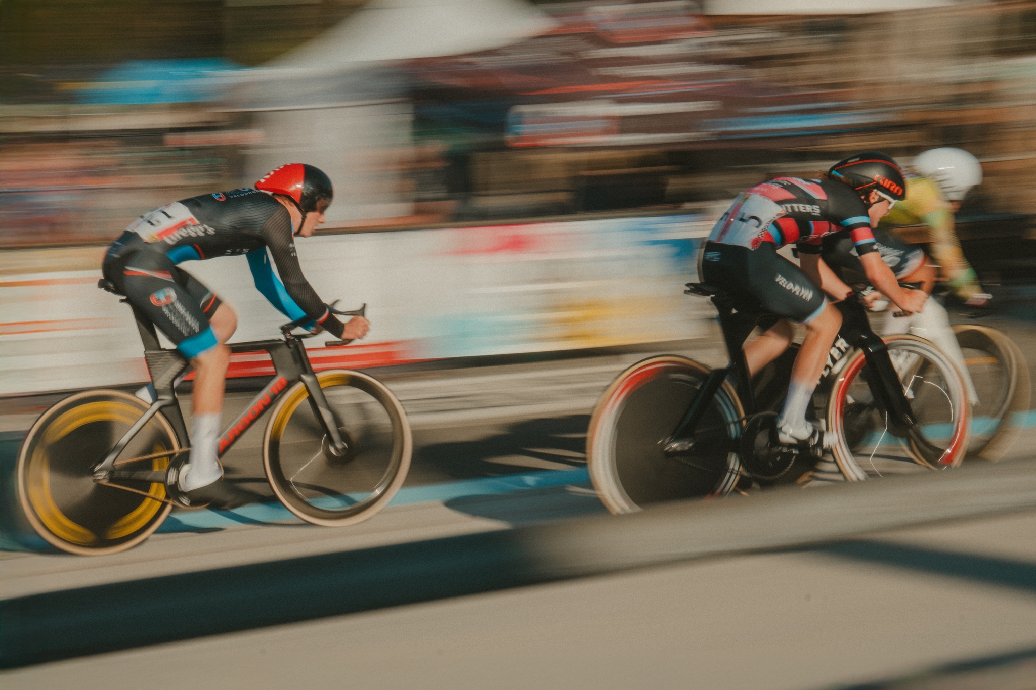 Cyclists racing at high speed, with motion blur emphasizing their rapid movement