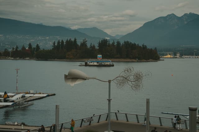 Distant island seen from a dock with mountains as the backdrop in a serene lakeside setting