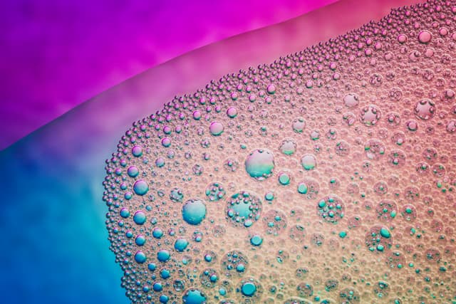 Bubbles of various sizes on a colorful gradient background, featuring shades of pink, purple, and blue