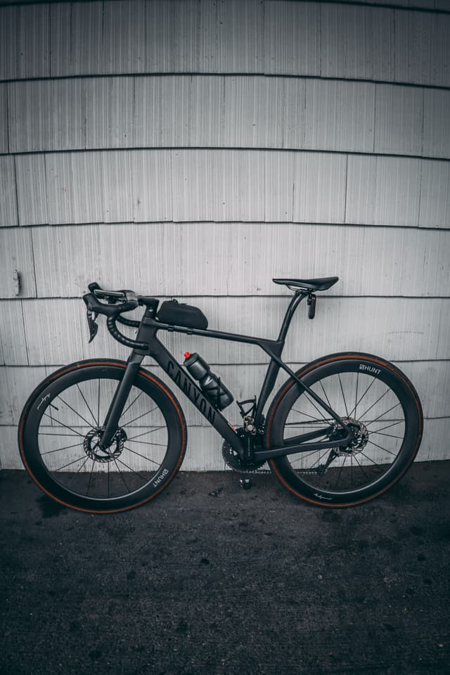 A black bike leaned against a wall