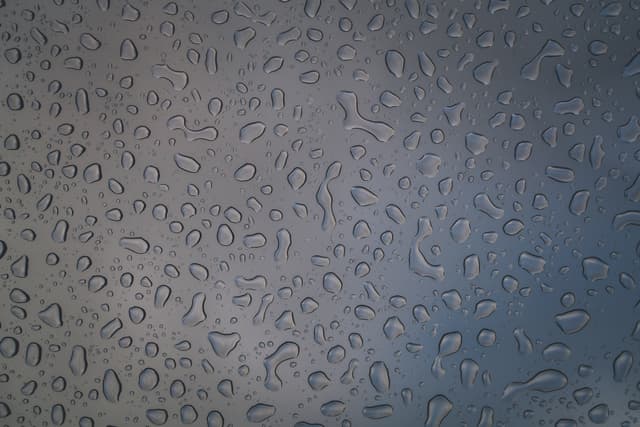 Water droplets on a glass surface with a blurred background