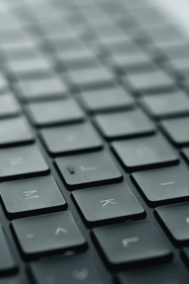 A close-up view of a black computer keyboard with a shallow depth of field, focusing on the keys