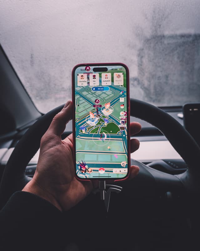 A mobile game displayed on a smartphone held by a person inside a car