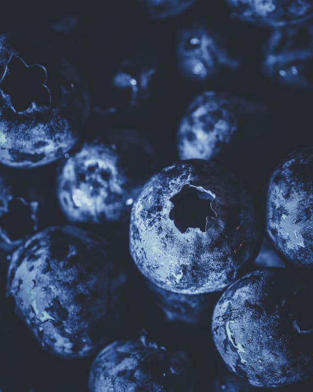 Close-up of ripe blueberries with a textured surface and deep blue hues