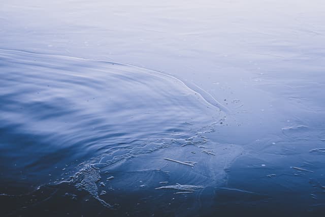 Calm blue water with gentle ripples and a serene, reflective surface